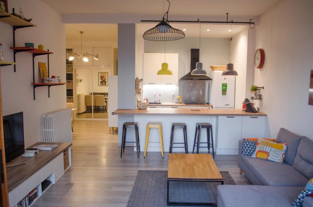 uma sala de estar e cozinha com um sofá e uma mesa em Le Baron em Évian-les-Bains