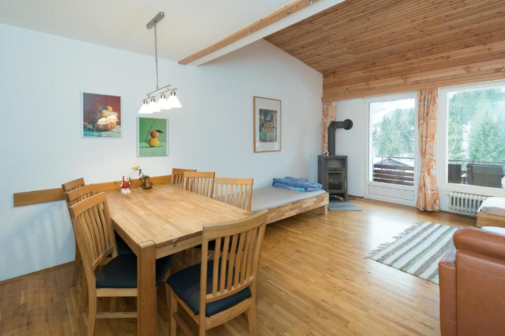 comedor y sala de estar con mesa de madera y sillas en Birkenhof - Schimek, en Bürserberg