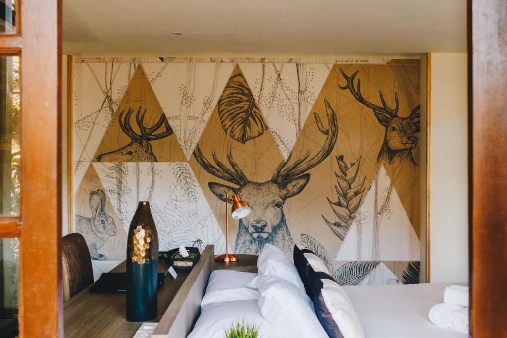 a wall with a mural of deer and antlers at Issara Boutique Winery Hotel in Muak Lek District