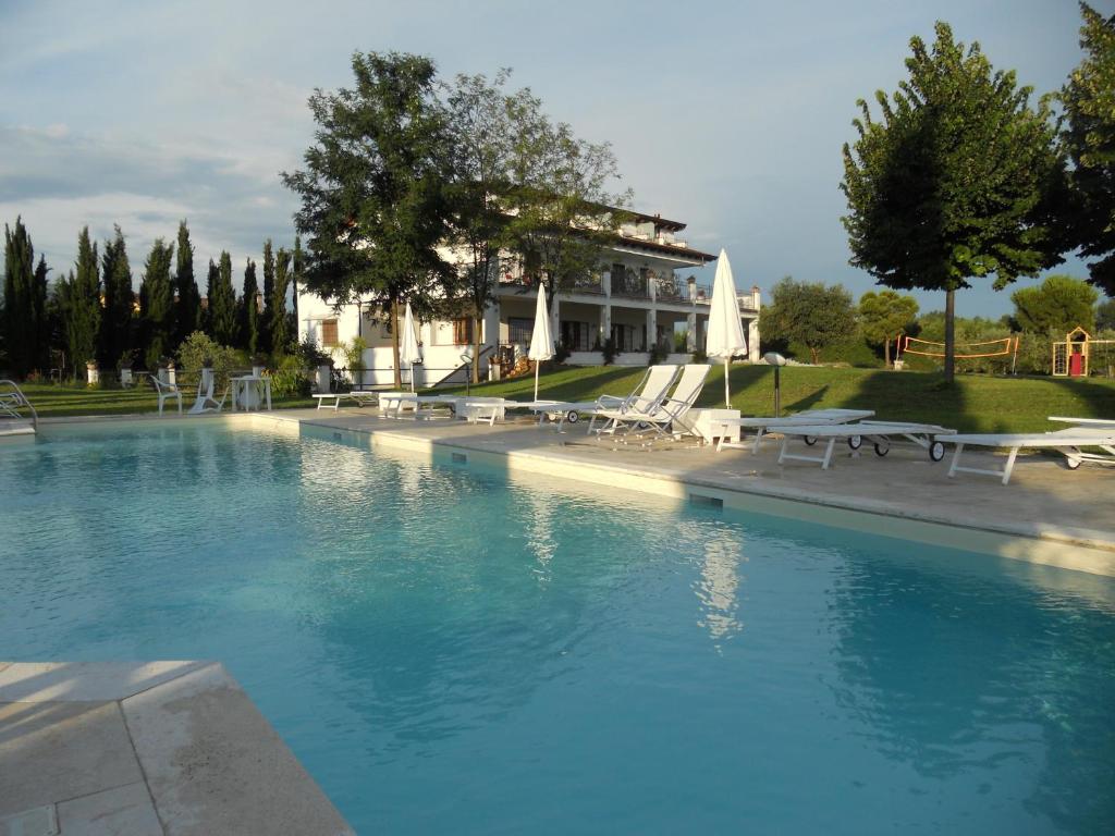 a swimming pool with chairs and a building in the background at B&B Radici24 in Battipaglia