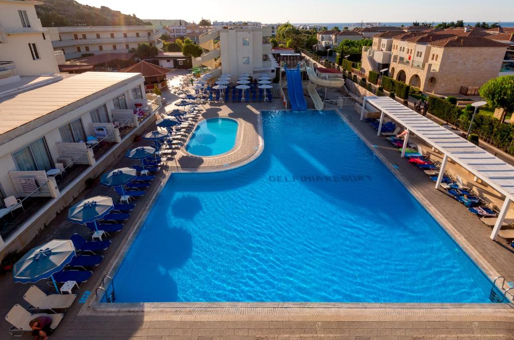 an aerial view of a hotel pool with chairs and umbrellas at Delfinia Resort - All Inclusive in Kolimbia