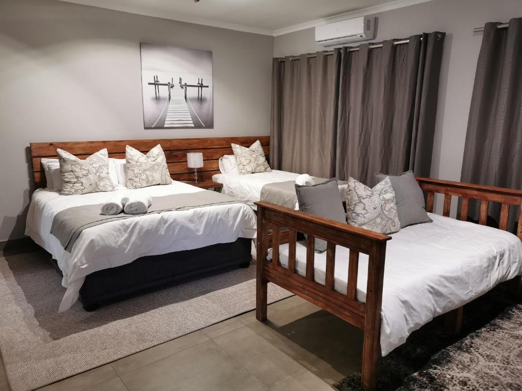 a bedroom with two beds and a window at Rosedene in Bloemfontein