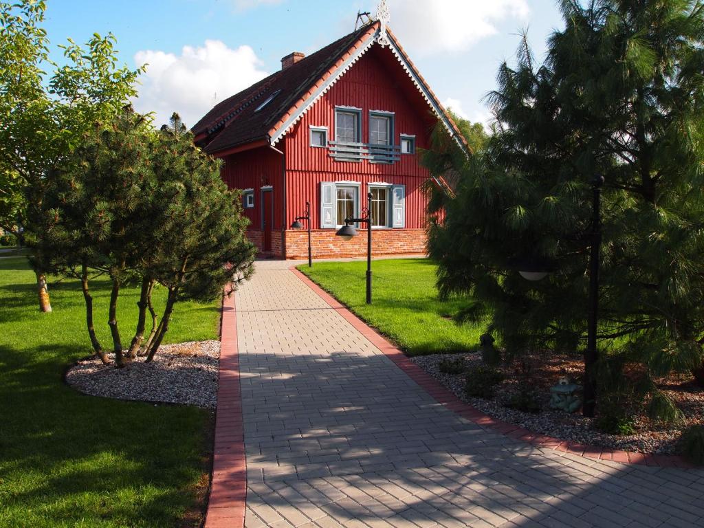 a red house with a pathway in front of it at Sodyba Senoji Rusnė in Rusnė