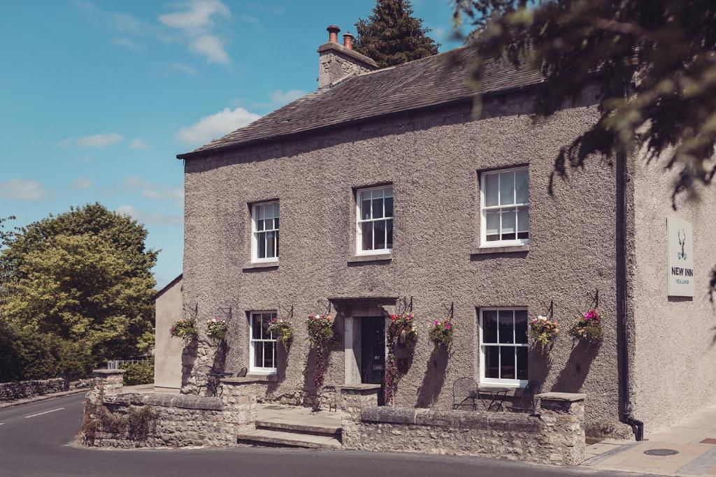 a large stone building with flowers on the windows at The New Inn in Carnforth