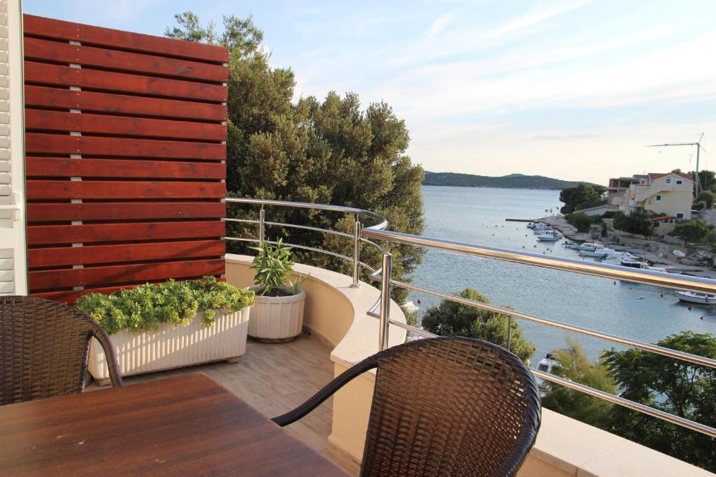 a balcony with a table and chairs and a view of the water at Apartments Time Off in Zaboric
