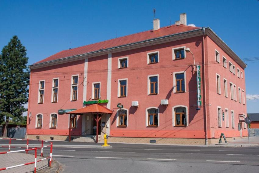 un gran edificio rojo en la esquina de una calle en Penzion SLANINA, en Kravaře