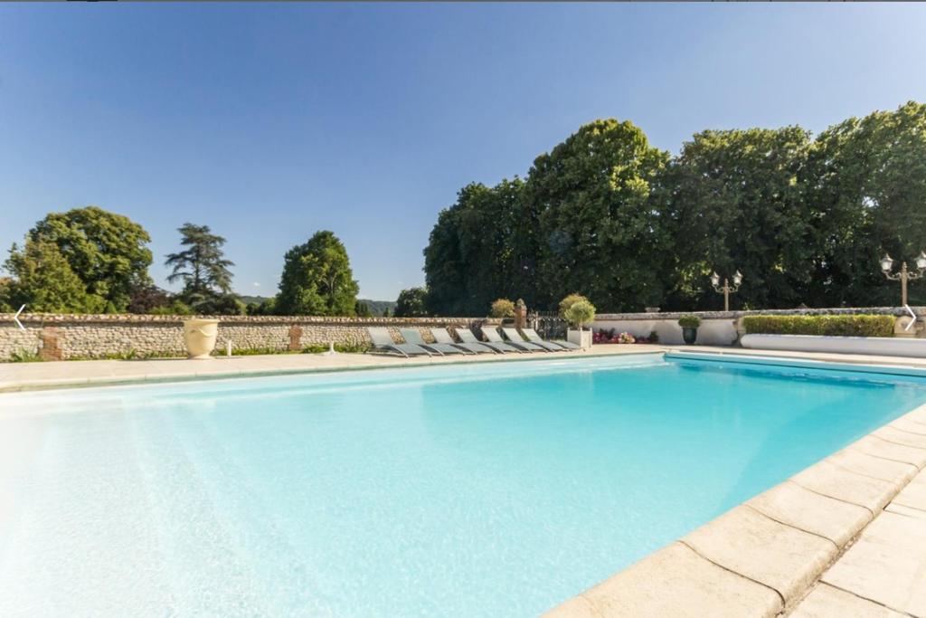 a large swimming pool with blue water at Grande villa d'exception en Normandie tennis, piscine, jacuzzi, salle de fitness in Muids