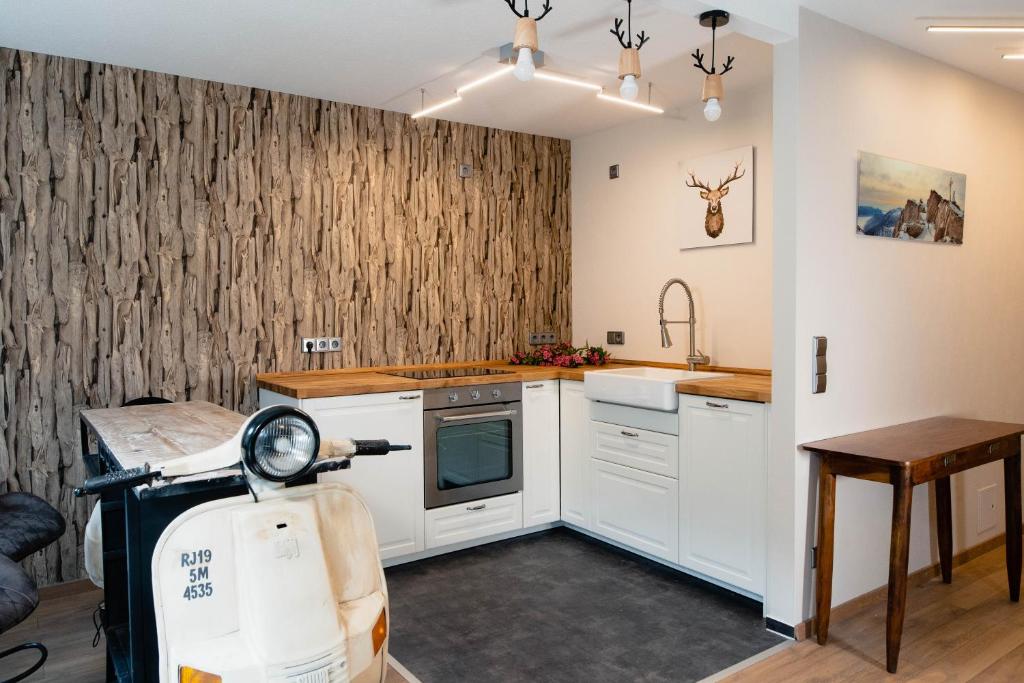 a kitchen with white cabinets and a scooter in it at Apartment Schwarz Waldperle in Bad Herrenalb