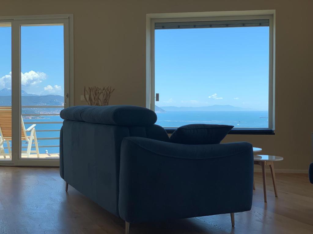 a living room with a blue couch and a large window at San Giorgio La Litoranea in La Spezia