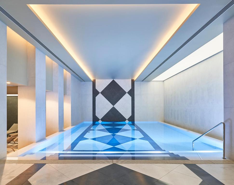 a swimming pool with a blue floor in a room at Savoy Palace - The Leading Hotels of the World - Savoy Signature in Funchal