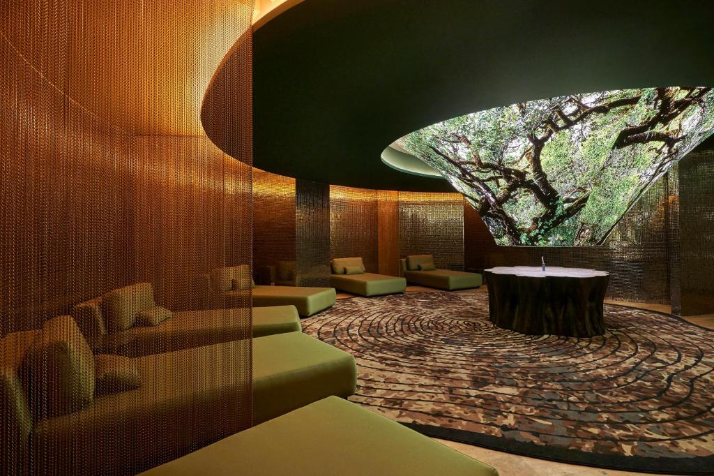a lobby with a tree and a table and chairs at Savoy Palace - The Leading Hotels of the World - Savoy Signature in Funchal