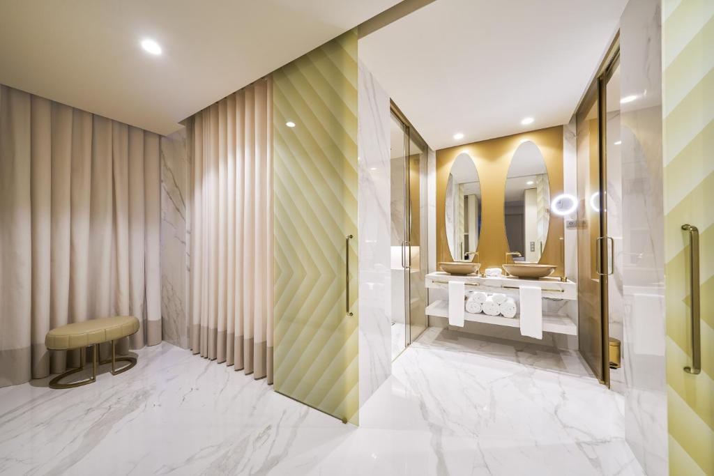 a bathroom with two sinks and a mirror at Savoy Palace - The Leading Hotels of the World - Savoy Signature in Funchal