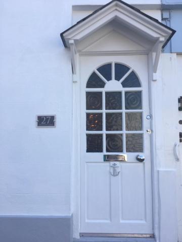 una puerta blanca de una casa blanca en Meadfoot Cottage, en Torquay