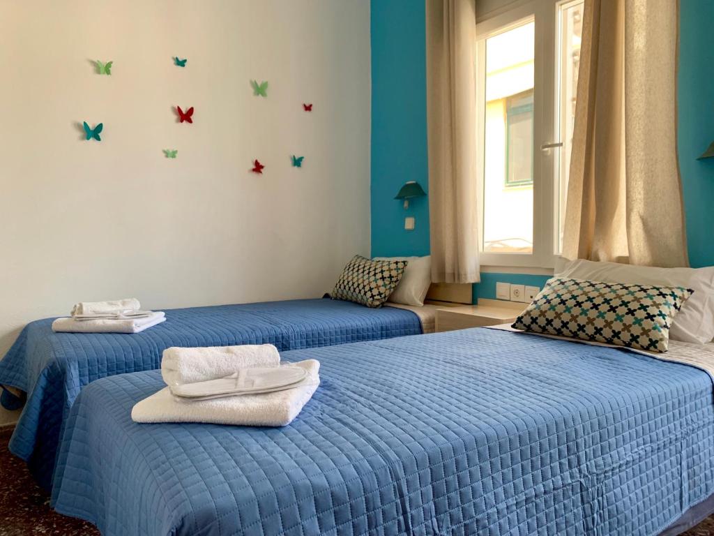 2 camas en una habitación con paredes azules en Mirtos Hotel en Myrtos