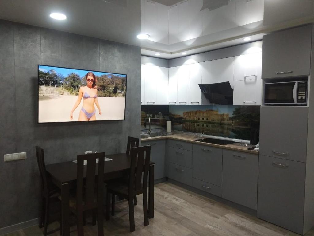 a kitchen with a table and a tv on the wall at Апарт-Отель - 12 шагов к морю, ЖК Орион in Odesa