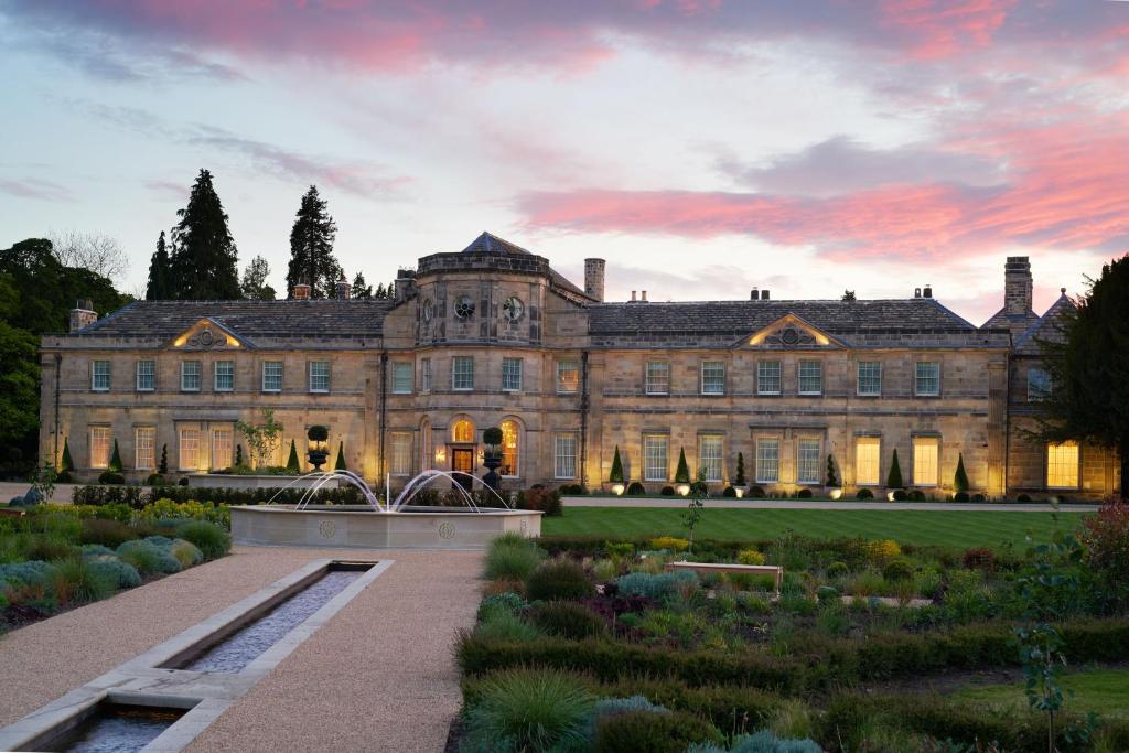 een groot gebouw met een tuin ervoor bij Grantley Hall in Ripon