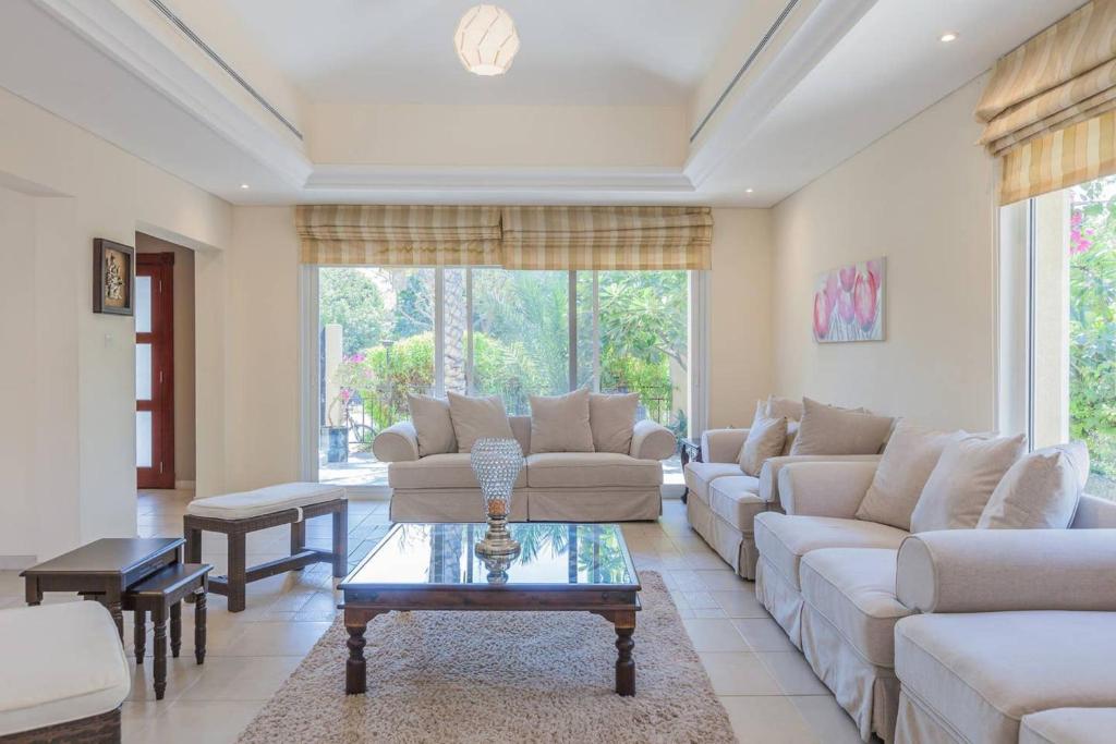 a living room with couches and a coffee table at Houst Holiday Homes - Green Commnity West in Dubai