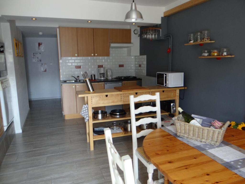 cocina con mesa de madera y comedor en Aux oiseaux de passage en Rosheim