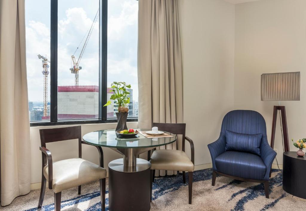 A window-side dining table with two chairs and a separate armchair.