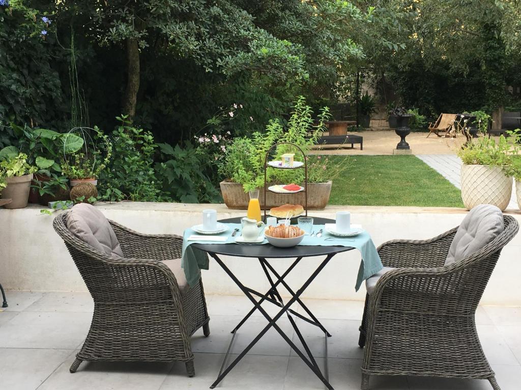 - une table avec deux chaises et une table avec de la nourriture dans l'établissement Chambre côté jardin, à Nîmes
