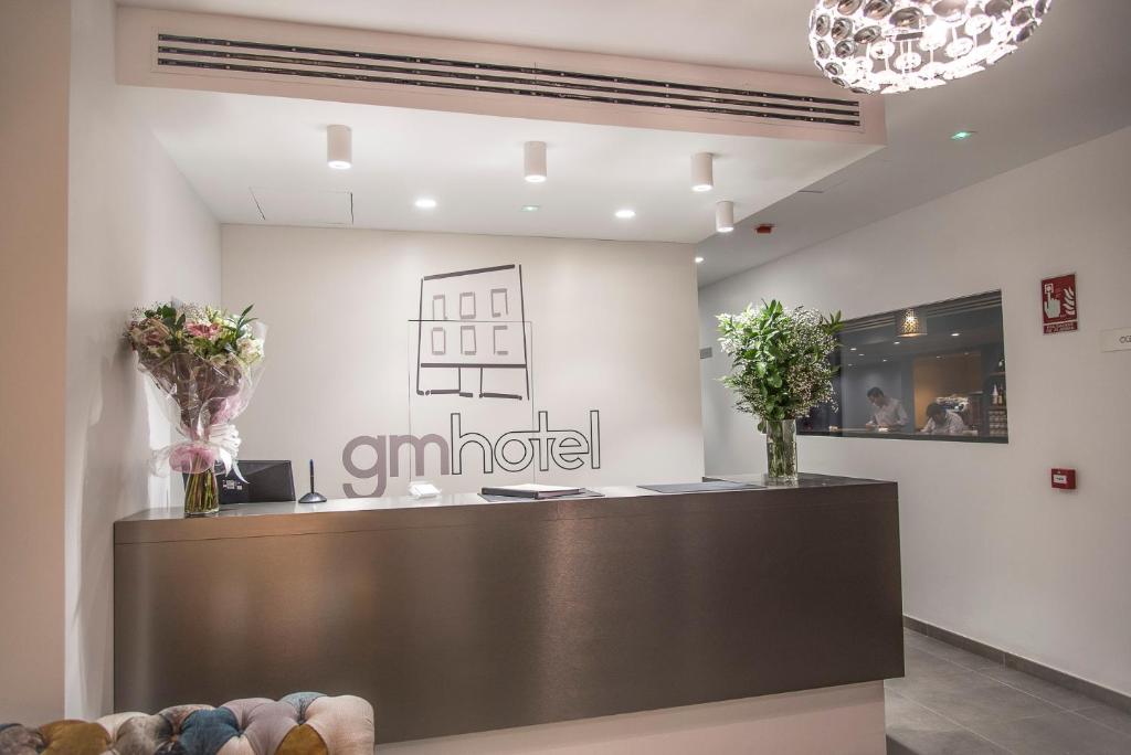 a lobby with a reception desk in a building at gm hotel in Marchena