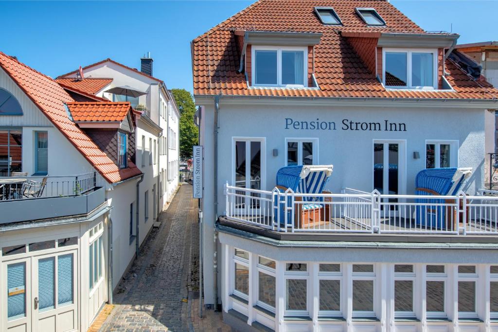 una fila di case con sedie blu sui balconi di Pension StromInn a Warnemünde
