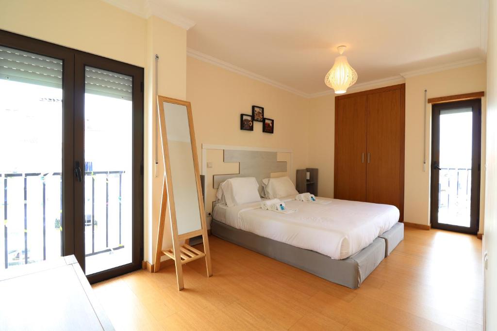 a bedroom with a bed and a large window at BeGuest Cascais INN Apartments_ Ocean View in Alcabideche