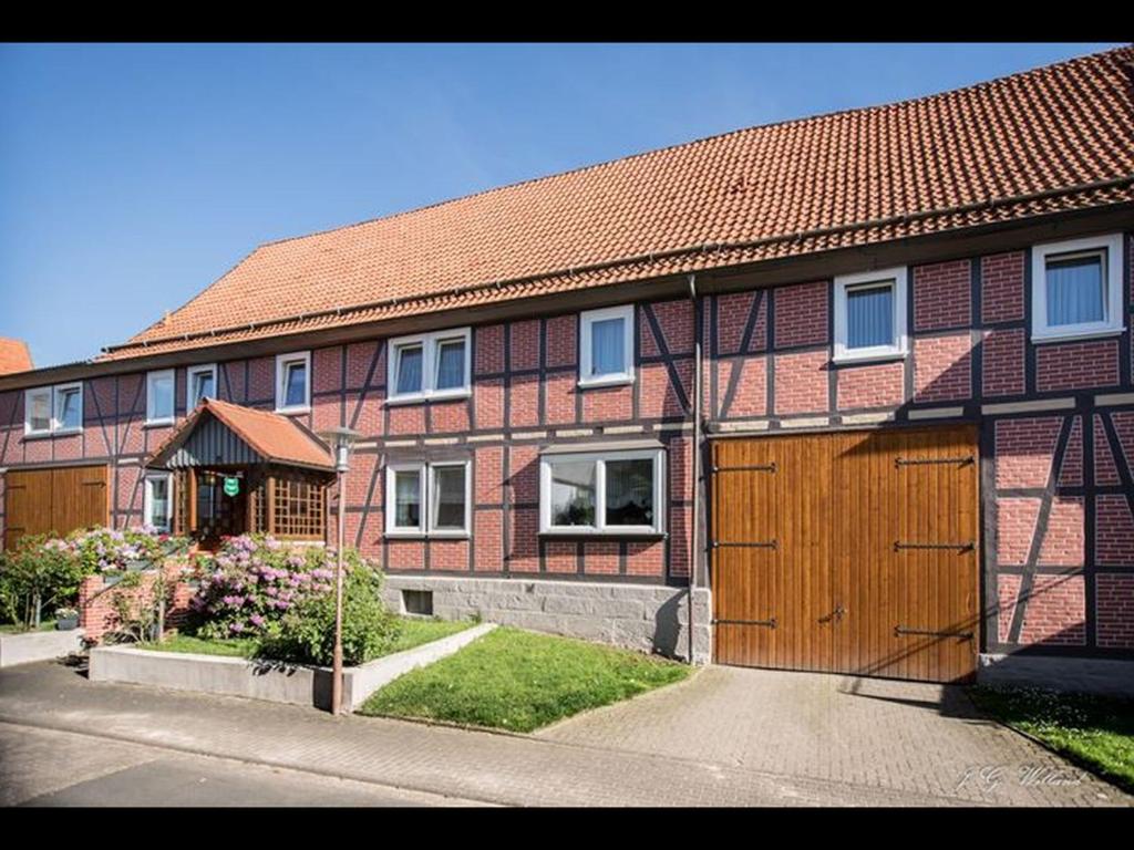 a large brick house with a large wooden garage at Ferienhof Koch in Oedelsheim