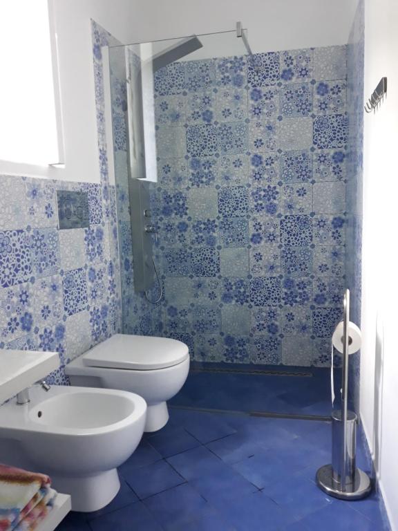 Baño de azulejos azules con aseo y lavamanos en Stromboliparadise Piscita, en Stromboli