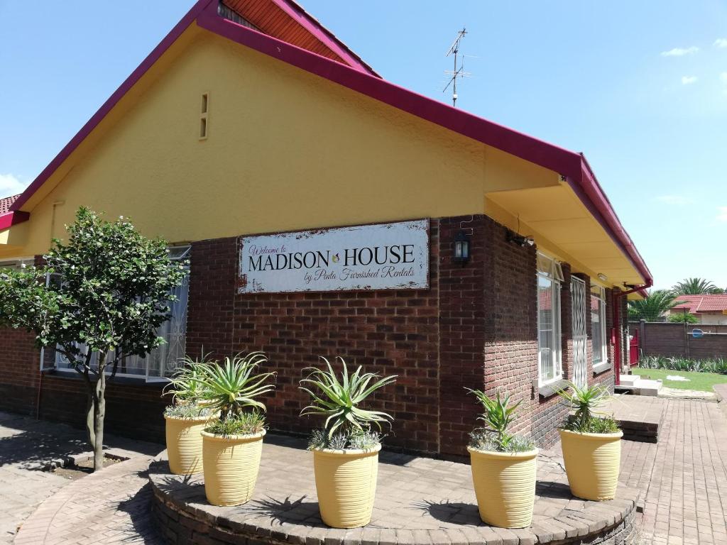 a brick house with potted plants in front of it at Fuhri Road Apartments Madison House in Alberton