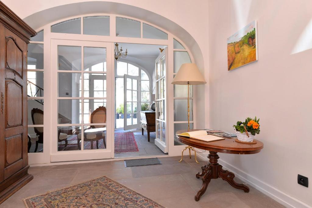 sala de estar con mesa de madera y puerta en Marquisat de Vauban - Exclusive home, en Neuf-Brisach