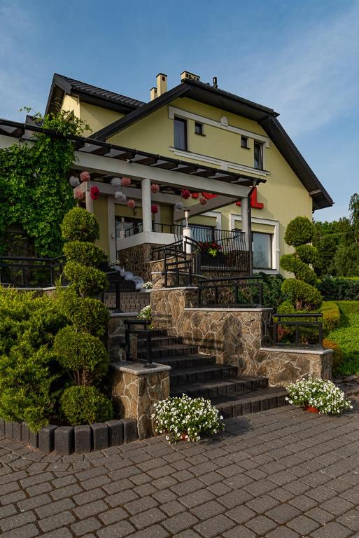 żółty dom ze schodami przed nim w obiekcie Hotel Konstancja w mieście Konstantynów Łódzki
