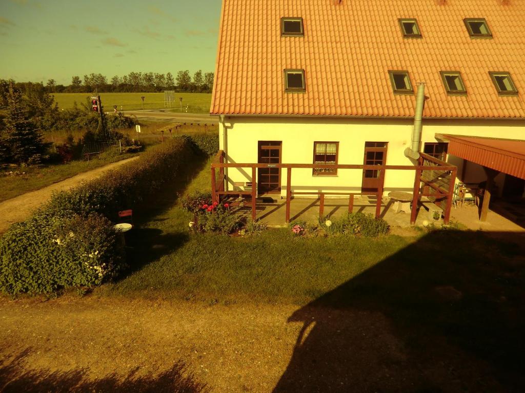 ein weißes Haus mit einem roten Dach und einem Hof in der Unterkunft Hotel Kranichblick in Kluis