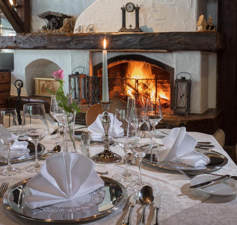 a table with a white table cloth and a fireplace at Hotel Höhlenstein in Tux