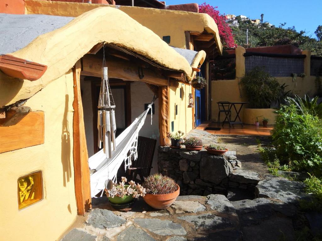 a house with potted plants sitting outside of it at La Cuevita in Santa Brígida