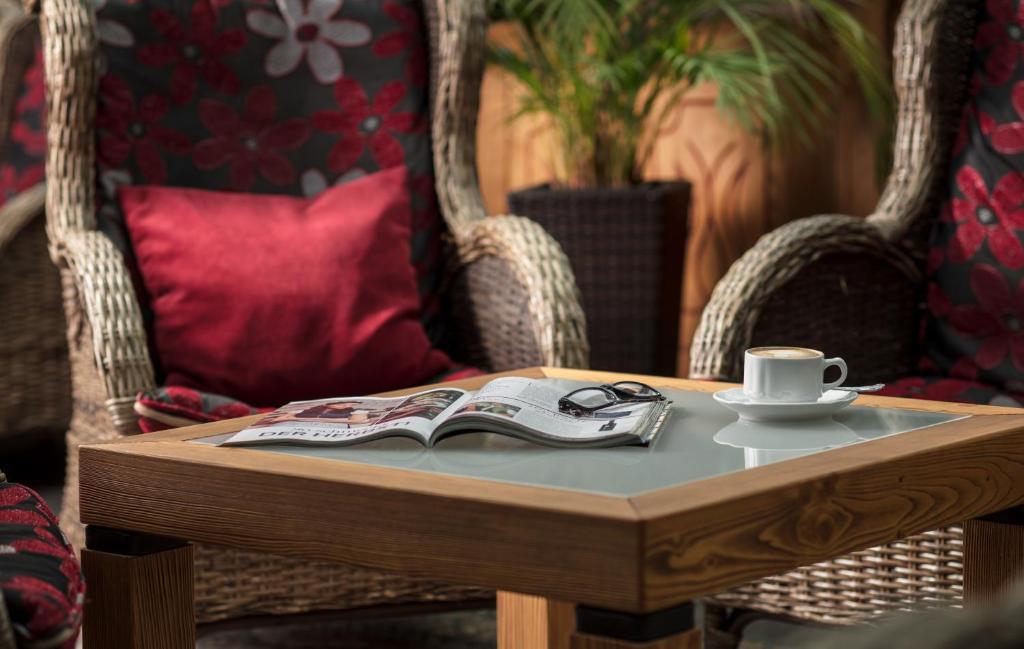 a coffee table with a book and a cup of coffee at Hotel Höhlenstein in Tux