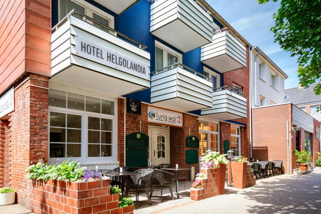 a hotel restaurant with tables and chairs on a street at Hotel Helgolandia in Helgoland