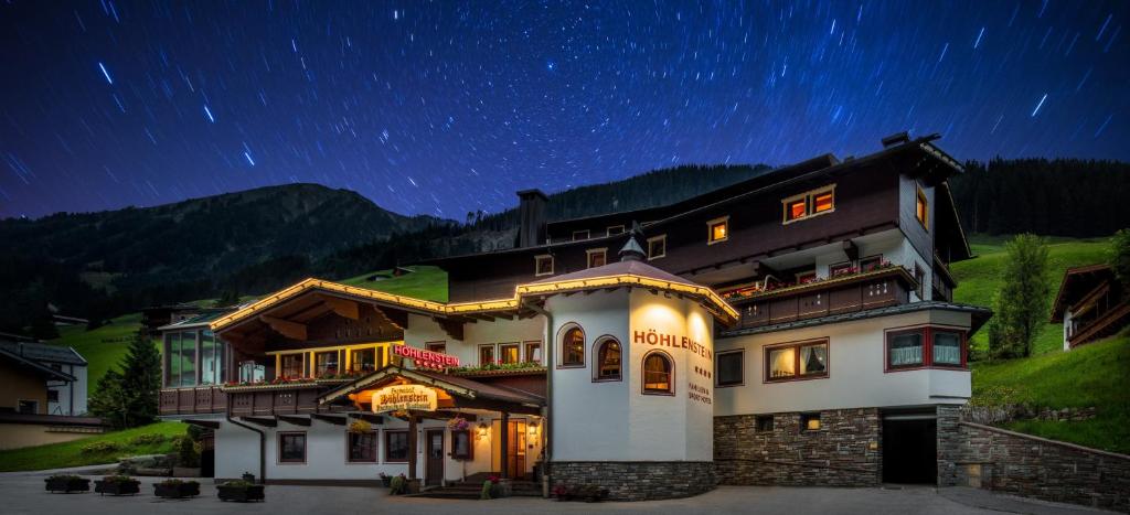a large house with a starry sky above it at Hotel Höhlenstein in Tux