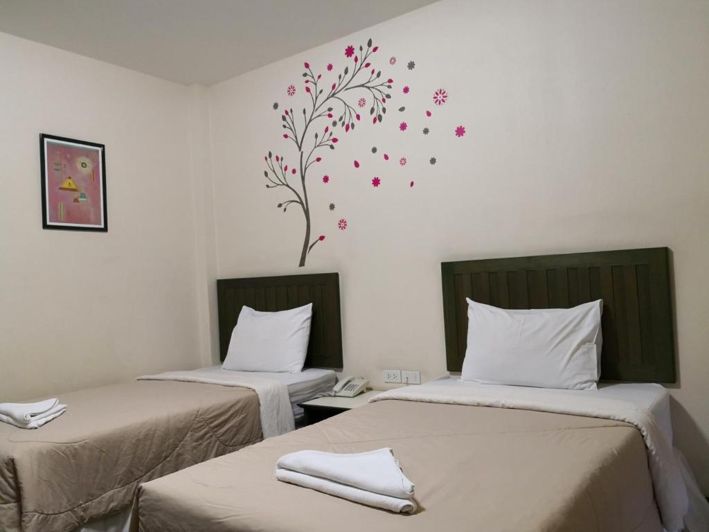 Postel nebo postele na pokoji v ubytování Baan Suksiri Hotel