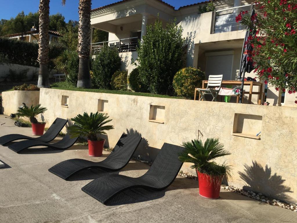 a row of black chairs in front of a house at Le Gîte du DAB in La Cadière-dʼAzur