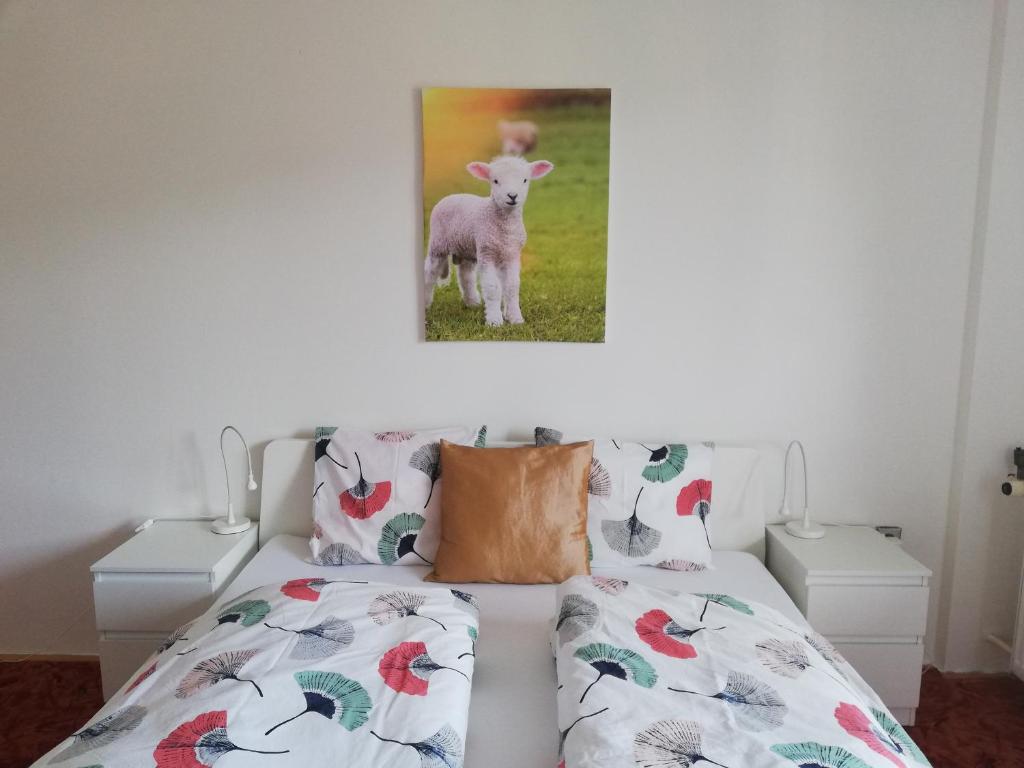 1 dormitorio con 1 cama con una foto de una oveja en Deštné 371 - Buďte na horách jako doma en Deštné v Orlických horách