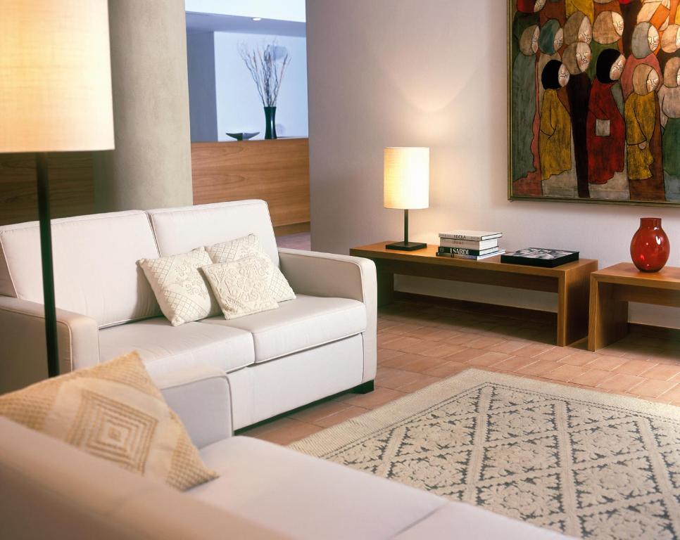 a living room with a white couch and a table at Hotel Aquadulci in Chia