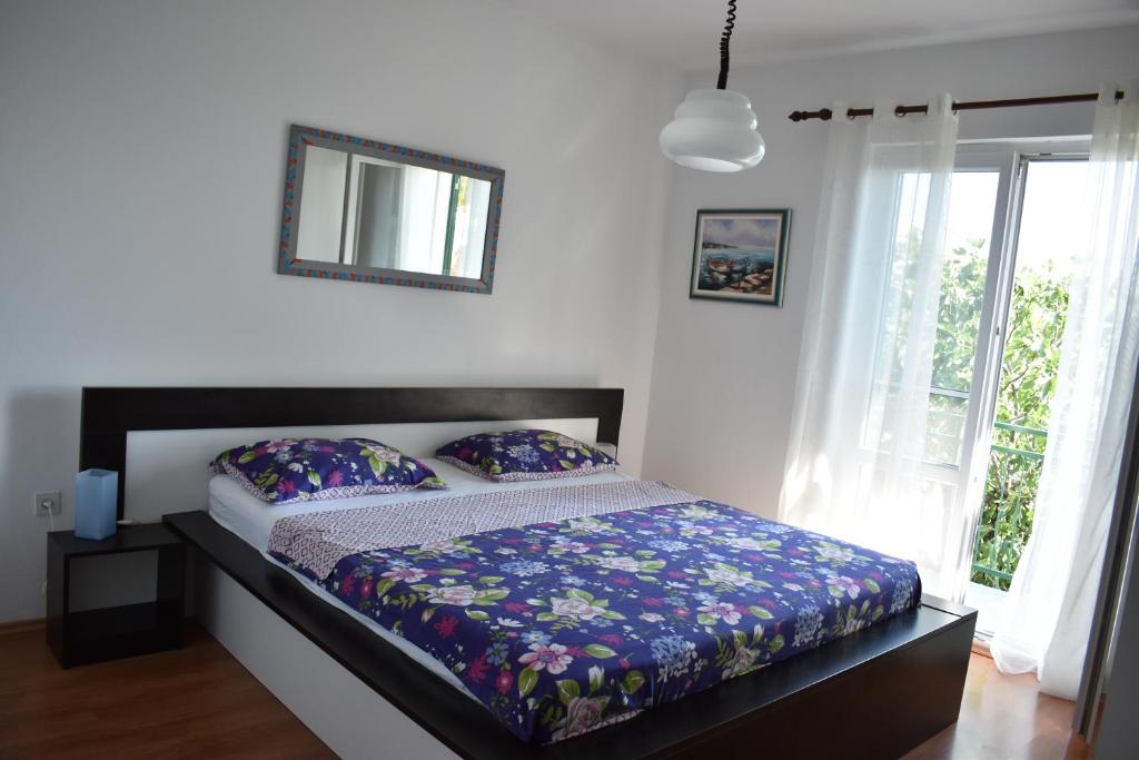 a bedroom with a bed and a window at Apartment Računica in Vodice