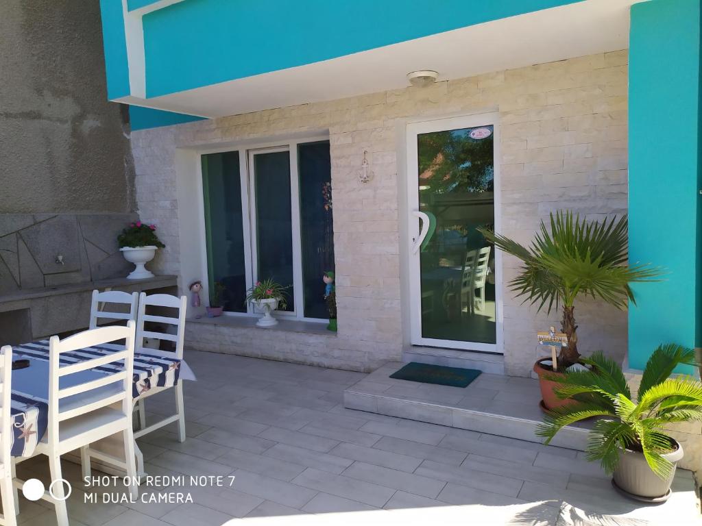 a patio with chairs and a glass door at Деси Къща за гости 1 in Chernomorets