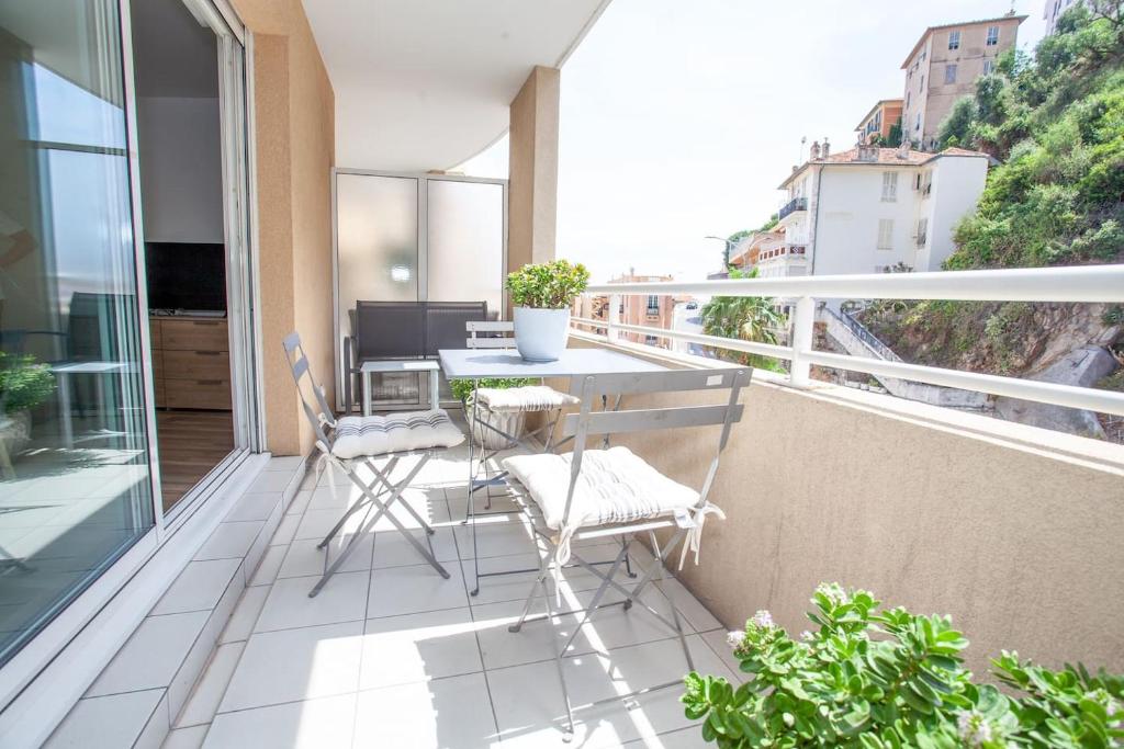 een balkon met een tafel en stoelen op een balkon bij Splendide studio Design frontiere Monaco in Beausoleil