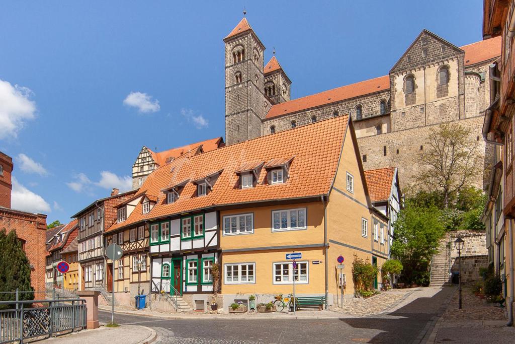 ein Gebäude mit einem Uhrturm vor einem Schloss in der Unterkunft Apartments Unter Dem Schloß in Quedlinburg
