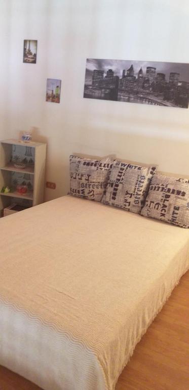sypialnia z dużym łóżkiem z plakatem na ścianie w obiekcie Happy Holiday w mieście Avola