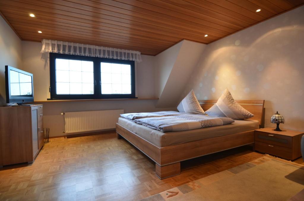 1 dormitorio con 1 cama y TV en Ferienwohnung Bouten A, en Geldern
