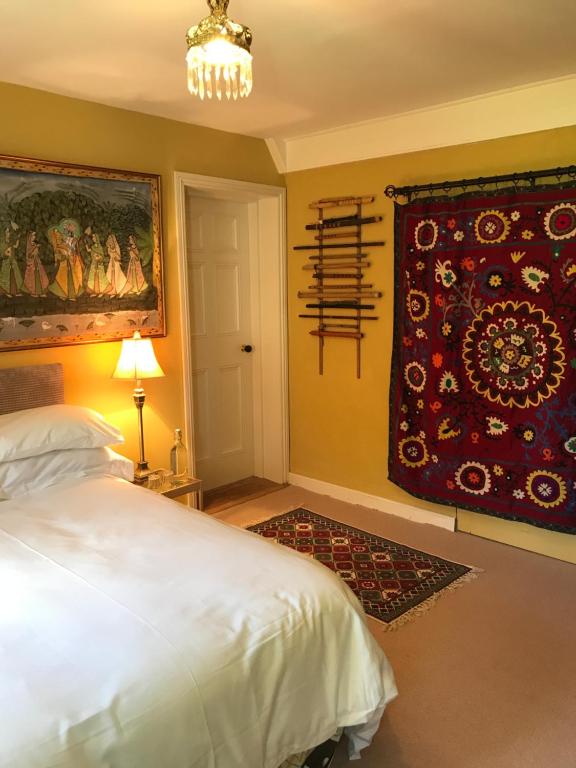 a bedroom with a bed and a painting on the wall at Corriebeg Cottage in Borris