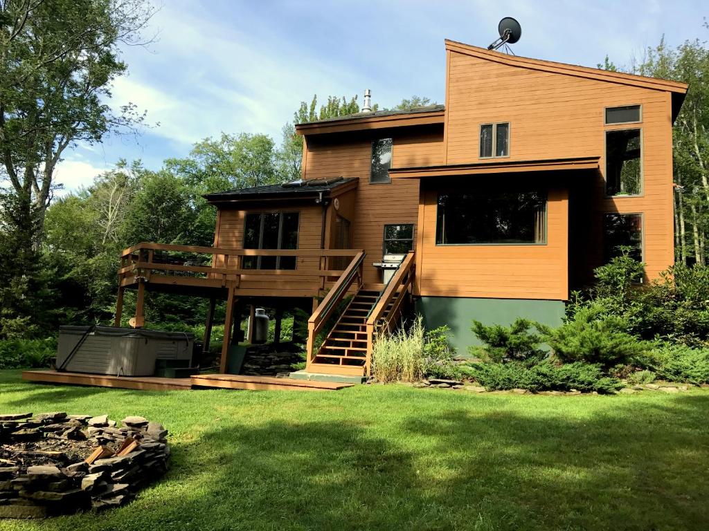 a house with a deck and a yard at Mink Hollow Lodge in Elka Park